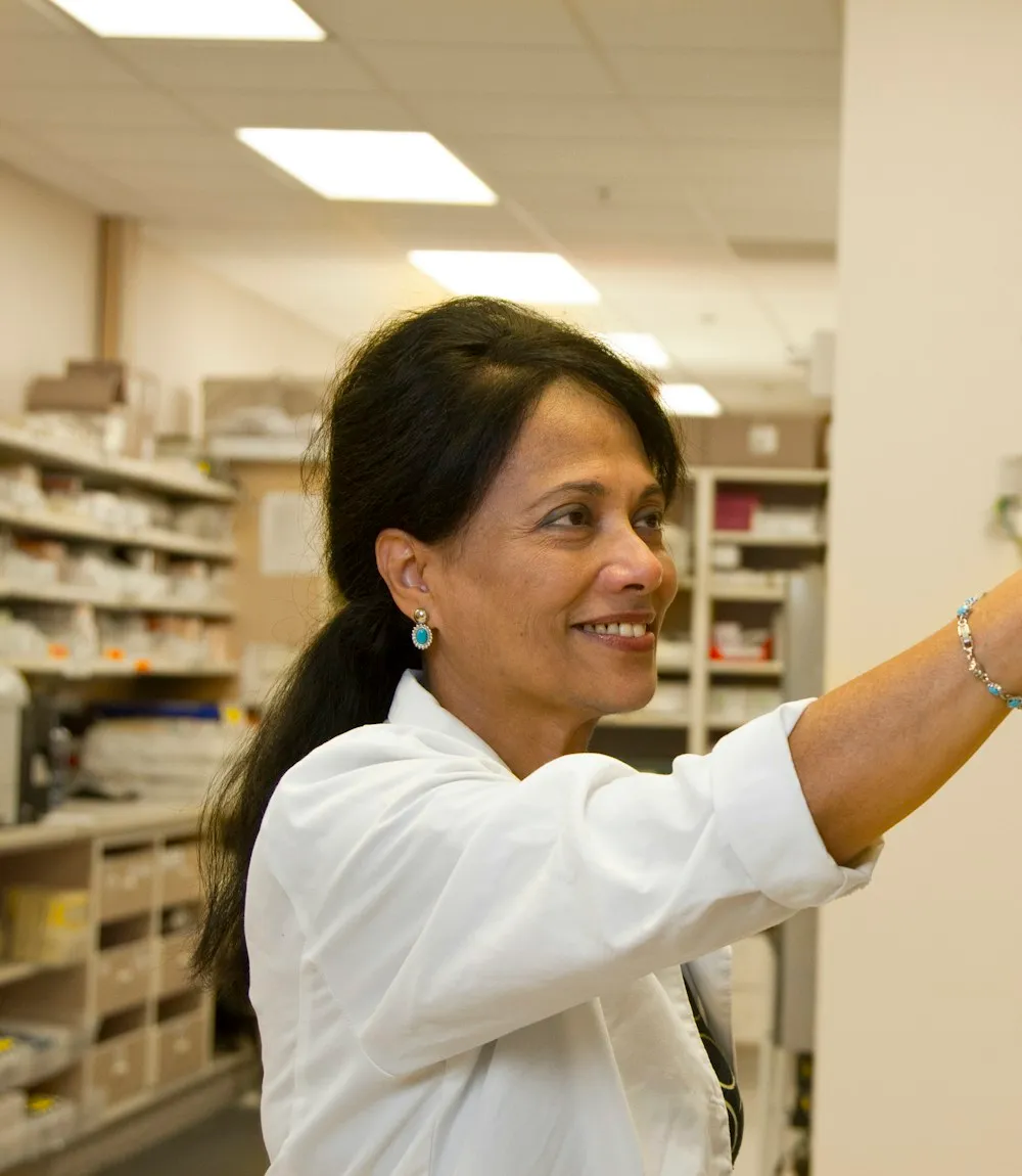 Pharmacist selecting a medicine from a pharmacy shelf