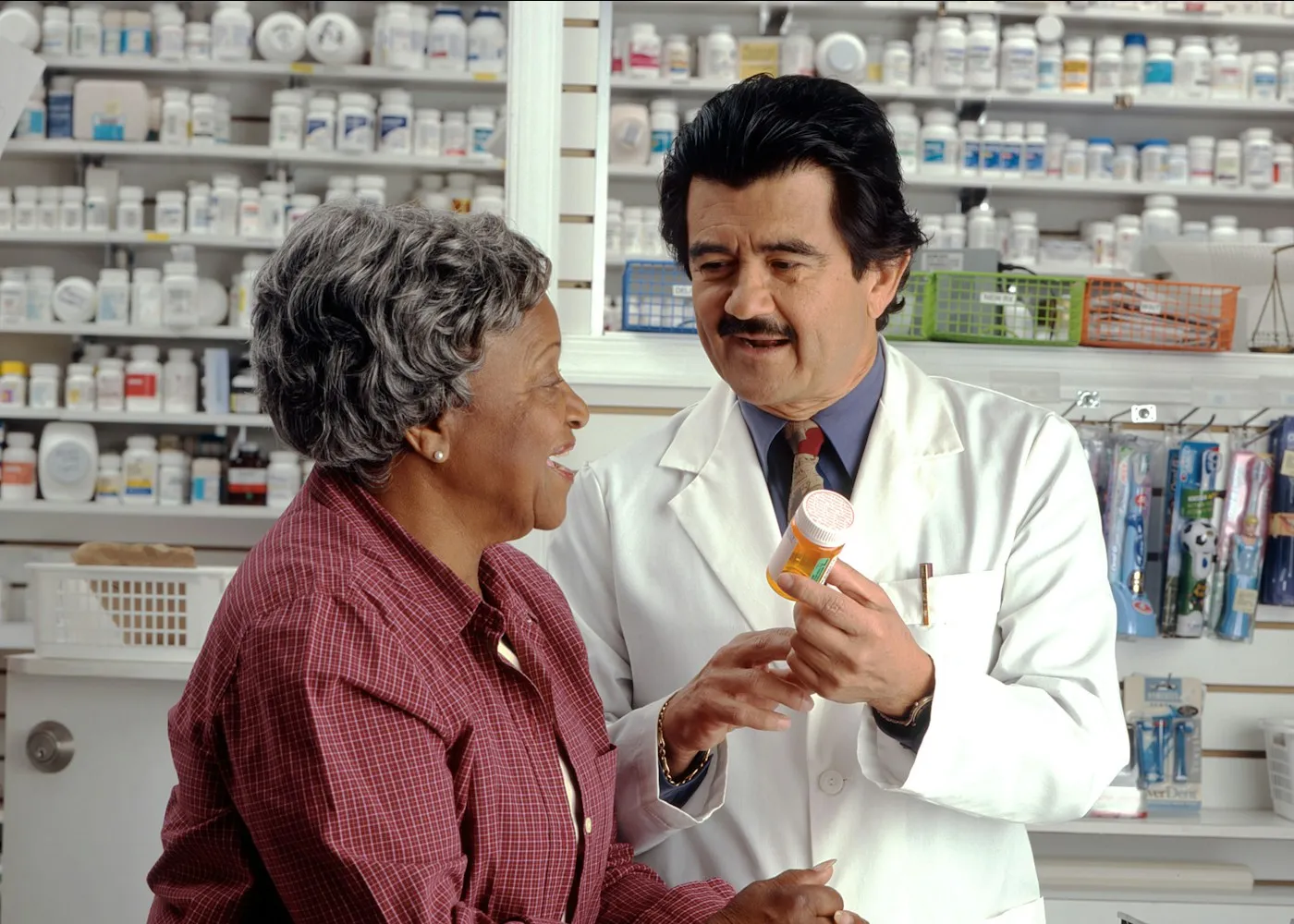 Pharmacist explaining a medicine to a customer at a pharmacy counter